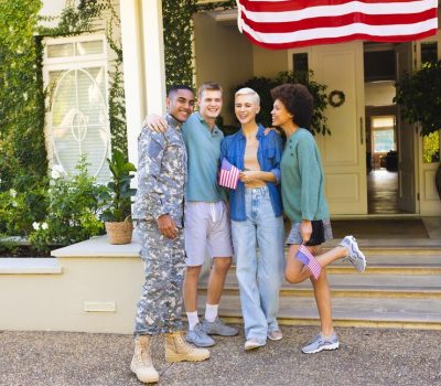 portrait-happy-diverse-group-friends-with-biracial-male-american-soldier-embracing-smiling-american-flag-homecoming-patriotism-military-service_13339-340736
